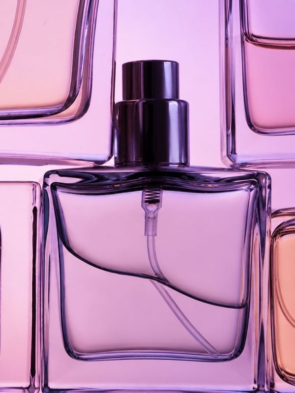 Glass flacons glowing pink, peach and lilac in backlight